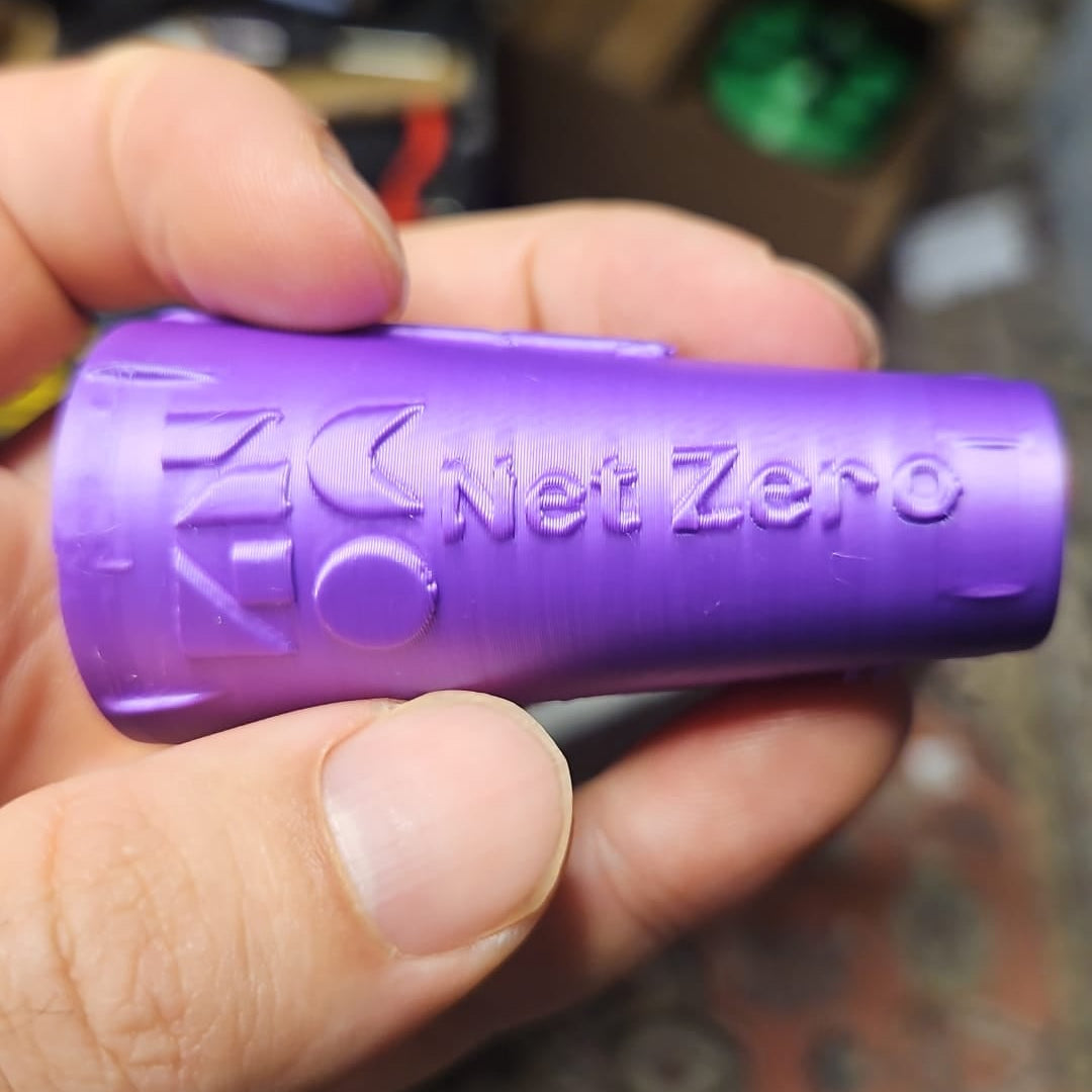 Ein Lilaner Umweltfreund mit dem Logo der net zero stadt Differdingen