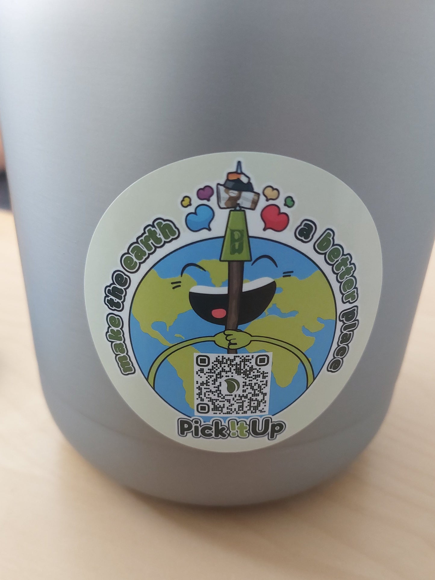 Ein Sticker auf dem ein QR-Code ist mit Earthy, dem Maskottchen und dem Schriftzug "Make the earth a  better place".