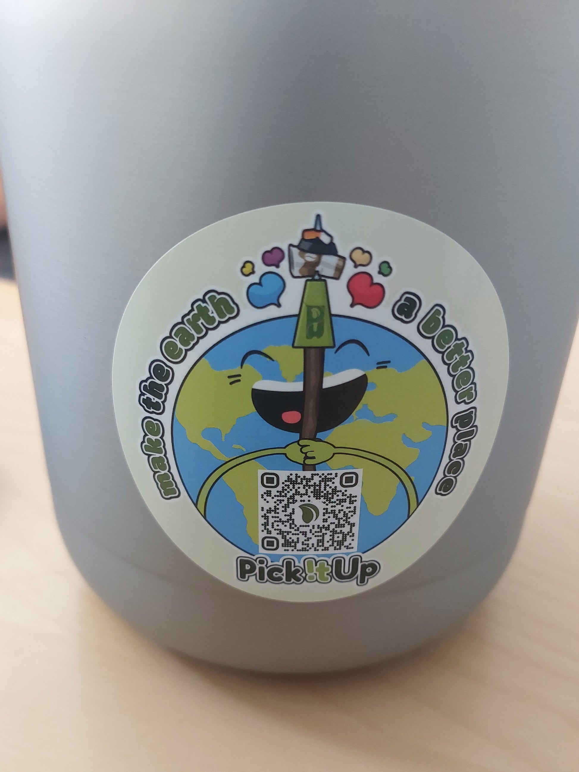 Ein Sticker auf dem ein QR-Code ist mit Earthy, dem Maskottchen und dem Schriftzug "Make the earth a  better place".